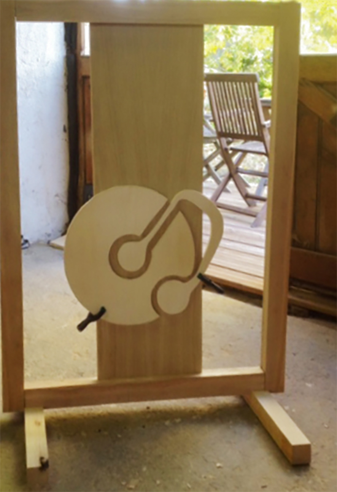 Création d'un petit pupitre moderne en bois clair avec un motif découpé représentant un disque et une note de musique entrelacés.